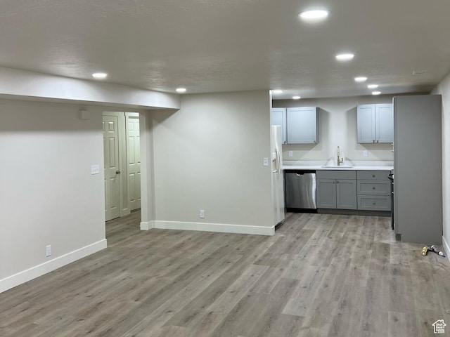 10861 N Panorama Dr, Highland, UT 84003 - kitchen with stainless steel dishwasher, a sink, white fridge with ice dispenser, recessed lighting, and baseboards