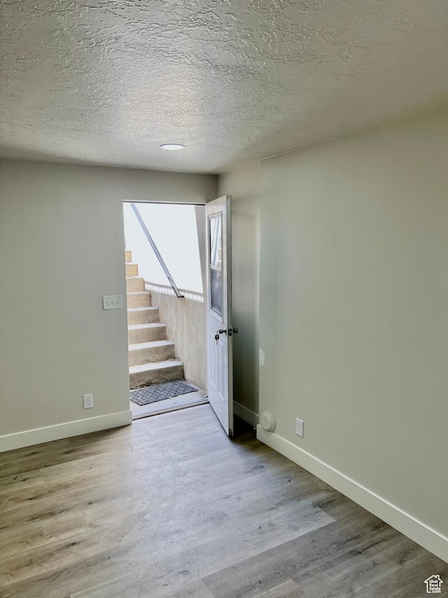 10861 N Panorama Dr, Highland, UT 84003 - empty room with baseboards, wood finished floors, stairs, and a textured ceiling