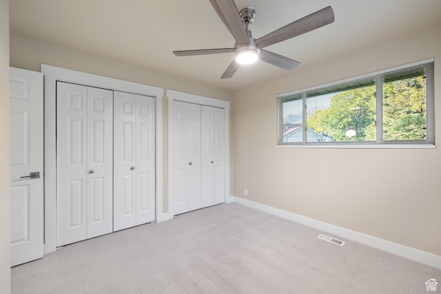10861 N Panorama Dr, Highland, UT 84003 - unfurnished bedroom with light carpet, multiple closets, baseboards, and a ceiling fan
