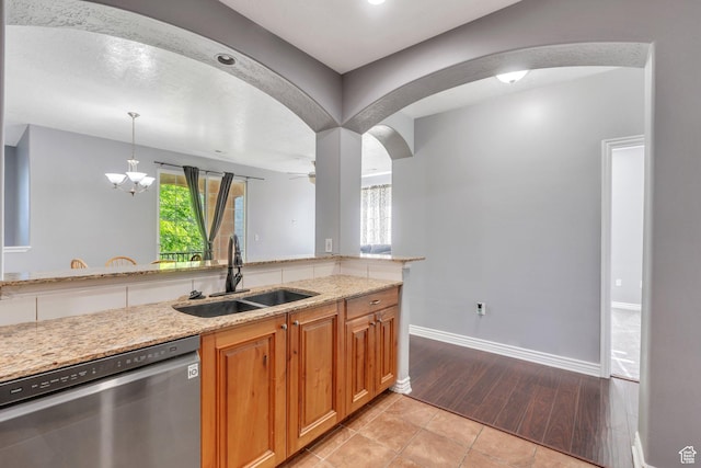 1292 W Dallin Dr N, Pleasant Grove, UT 84062 - kitchen with stainless steel dishwasher, a sink, arched walkways, light stone countertops, and baseboards
