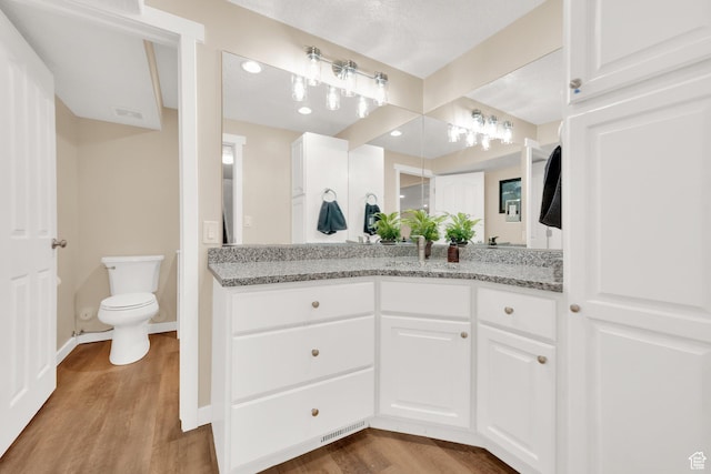 4234 W Swensen Farm Dr S, Riverton, UT 84096 - bathroom featuring wood finished floors, vanity, toilet, and baseboards