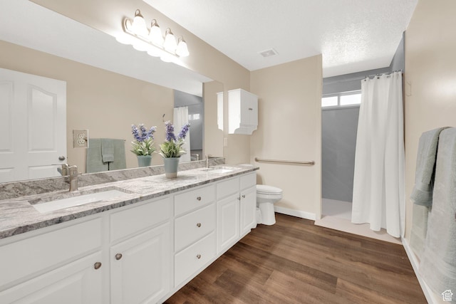 4234 W Swensen Farm Dr S, Riverton, UT 84096 - bathroom featuring toilet, double vanity, a shower with curtain, wood finished floors, and baseboards