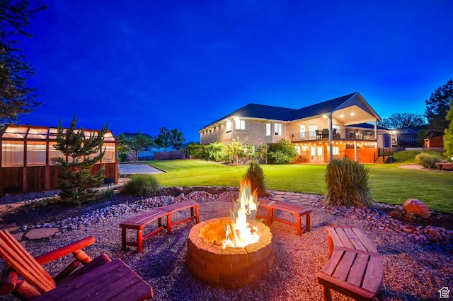 4234 W Swensen Farm Dr S, Riverton, UT 84096 - patio at night featuring an outdoor fire pit, a lawn, and a balcony