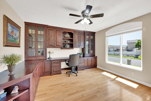 4234 W Swensen Farm Dr S, Riverton, UT 84096 - home office featuring built in desk, ceiling fan, light wood-style flooring, and baseboards