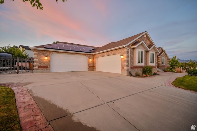 4234 W Swensen Farm Dr S, Riverton, UT 84096 - ranch-style house featuring concrete driveway, an attached garage, brick siding, roof mounted solar panels, and a shingled roof