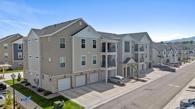 3665 W 1380 N Unit T201, Lehi, UT 84043 - view of building exterior with a residential view, concrete driveway, an attached garage, and a mountain view