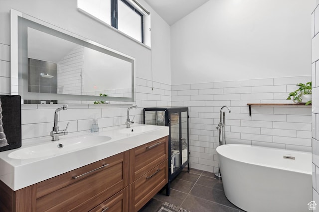 939 S Donner Way Unit 308, Salt Lake City, UT 84108 - bathroom with double vanity, tile walls, a freestanding tub, tile patterned flooring, and wainscoting