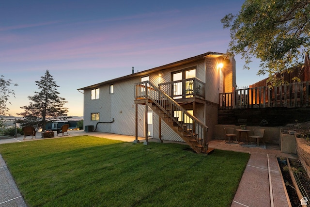 582 S Marialana Way E, North Salt Lake, UT 84054 - back of property at dusk featuring stairs, a patio area, a deck, and an outdoor fire pit
