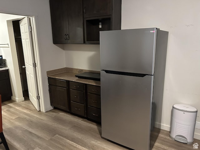620 W Main St, Green River, UT 84525 - kitchen featuring freestanding refrigerator, light wood finished floors, baseboards, and dark countertops