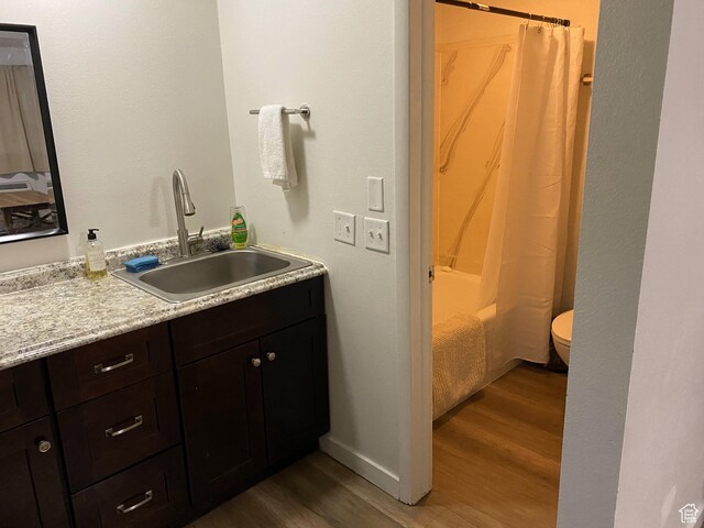 620 W Main St, Green River, UT 84525 - full bath featuring wood finished floors, vanity, toilet, and shower / tub combo