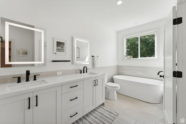 786 S 820 E, Pleasant Grove, UT 84062 - bathroom featuring double vanity, a freestanding bath, toilet, tile walls, and wainscoting