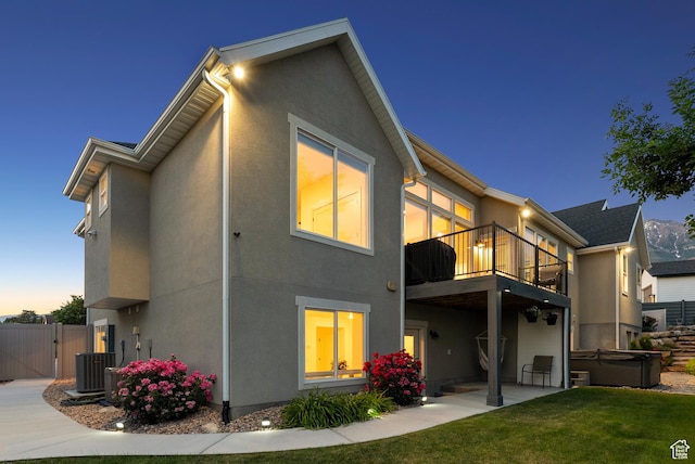 786 S 820 E, Pleasant Grove, UT 84062 - back of property at dusk featuring a hot tub, a balcony, stucco siding, a gate, and a patio area