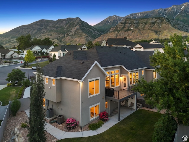 786 S 820 E, Pleasant Grove, UT 84062 - back of property at dusk featuring stucco siding, a mountain view, a shingled roof, cooling unit, and a patio