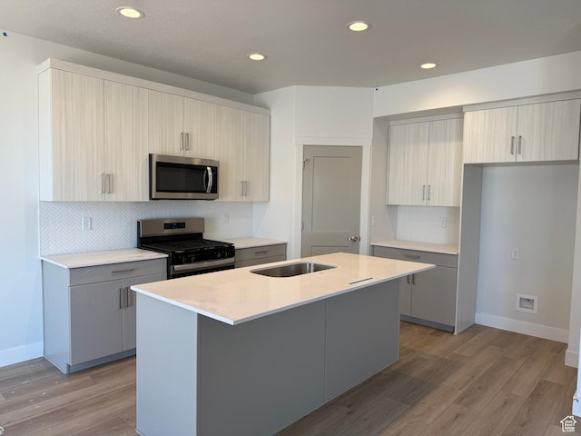 4582 W 3725 S Unit 241, West Haven, UT 84401 - kitchen with range with gas cooktop, stainless steel microwave, a sink, light countertops, and light wood-type flooring