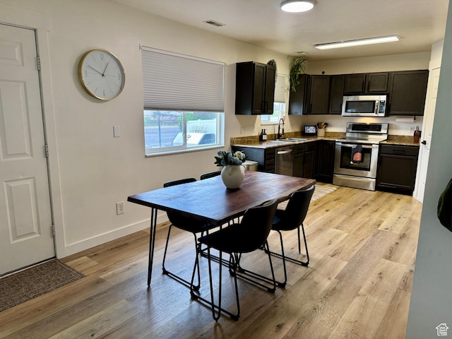 1720 N 2340 W, Lehi, UT 84043 - kitchen featuring stainless steel appliances, a sink, light wood-style flooring, baseboards, and dark cabinets