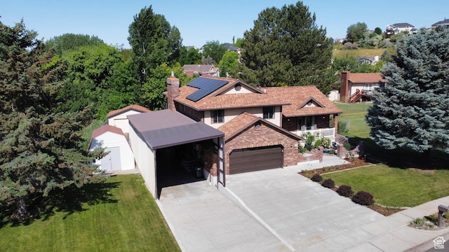 1735 Hayes Dr, Layton, UT 84040 - view of front of property featuring a front yard, roof mounted solar panels, a chimney, brick siding, and driveway