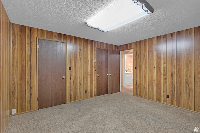 895 E 1015 S, Ogden, UT 84404 - unfurnished bedroom featuring a textured ceiling, carpet floors, and wood walls