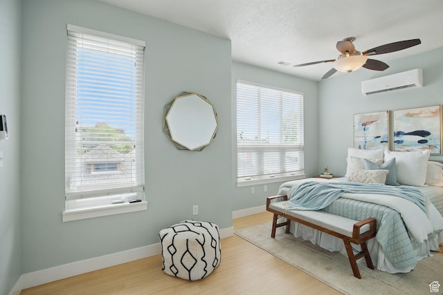 333 E Stanton Ave S, Salt Lake City, UT 84111 - bedroom featuring a wall mounted air conditioner, wood finished floors, baseboards, and a ceiling fan