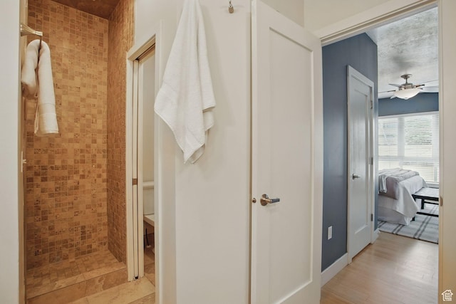 333 E Stanton Ave S, Salt Lake City, UT 84111 - bathroom featuring ceiling fan, connected bathroom, tiled shower, and wood finished floors