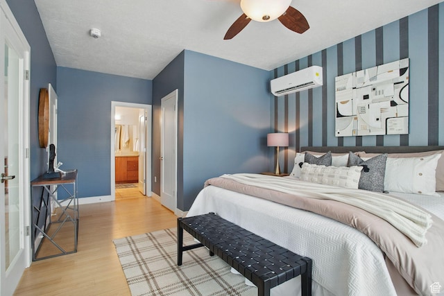 333 E Stanton Ave S, Salt Lake City, UT 84111 - bedroom with a wall unit AC, wood finished floors, baseboards, wallpapered walls, and ensuite bath
