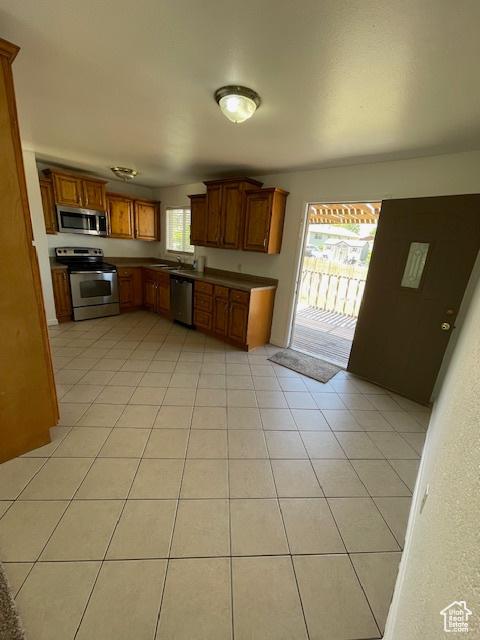 3780 S 7200 W, Magna, UT 84044 - kitchen with stainless steel appliances, a sink, dark countertops, and brown cabinetry
