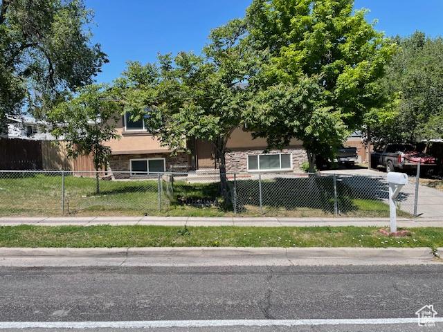3780 S 7200 W, Magna, UT 84044 - obstructed view of property featuring a fenced front yard and stone siding