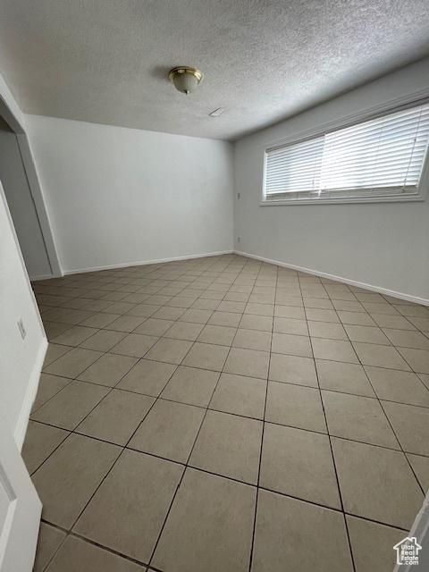 3780 S 7200 W, Magna, UT 84044 - spare room with a textured ceiling, light tile patterned flooring, and baseboards