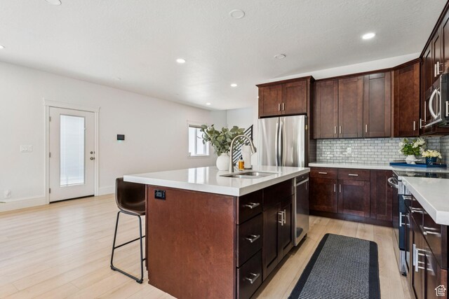 105 S 600 E, Provo, UT 84606 - kitchen with stainless steel appliances, light wood-type flooring, a center island, backsplash, and a sink