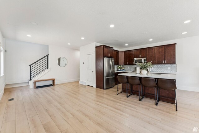 105 S 600 E, Provo, UT 84606 - kitchen with appliances with stainless steel finishes, light countertops, backsplash, recessed lighting, and a breakfast bar area