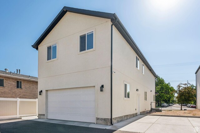 105 S 600 E, Provo, UT 84606 - view of property exterior featuring an attached garage, stucco siding, and driveway