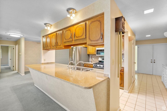 2718 E 200 N, Layton, UT 84040 - kitchen featuring stainless steel appliances, a sink, a peninsula, brown cabinetry, and decorative backsplash