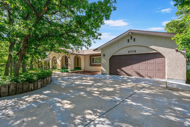 2718 E 200 N, Layton, UT 84040 - view of front facade featuring driveway, stucco siding, an attached garage, and a porch