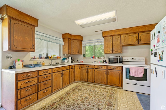 2718 E 200 N, Layton, UT 84040 - kitchen with white appliances, a sink, brown cabinets, light countertops, and a textured ceiling