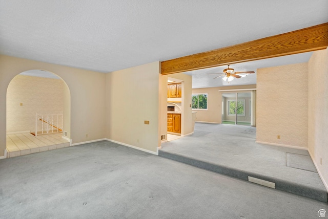 2718 E 200 N, Layton, UT 84040 - carpeted spare room with arched walkways, baseboards, a ceiling fan, a textured ceiling, and beam ceiling