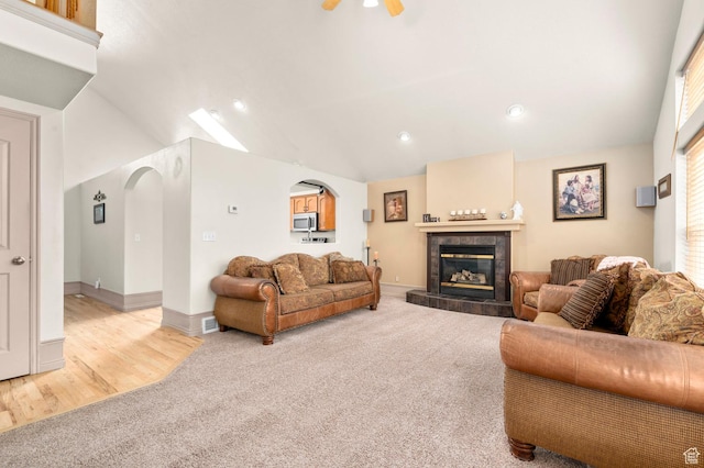 14008 S Emmeline Dr, Herriman, UT 84096 - living area with light carpet, arched walkways, vaulted ceiling, a tile fireplace, and recessed lighting