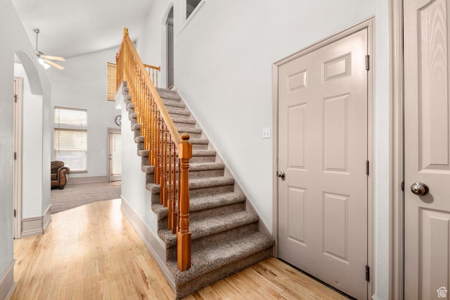 14008 S Emmeline Dr, Herriman, UT 84096 - stairs featuring arched walkways, wood finished floors, baseboards, a towering ceiling, and ceiling fan