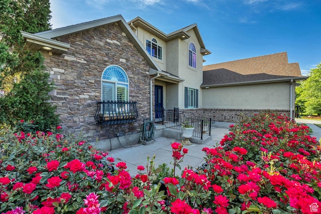 5258 N Ponderosa Ln, Stansbury Park, UT 84074 - traditional-style house with stucco siding, stone siding, and a patio