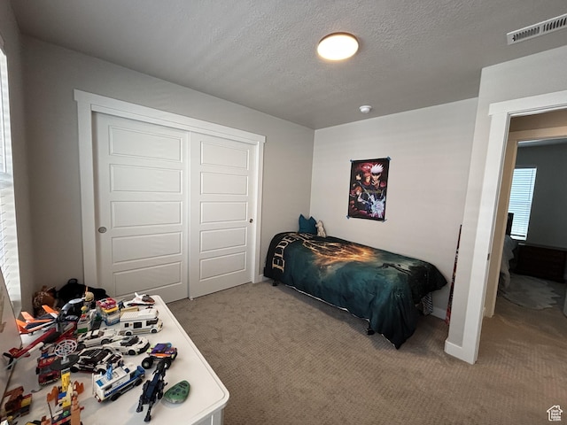 11603 S Outfitter Way S, Jordan, UT 84009 - bedroom featuring light carpet, a closet, a textured ceiling, and baseboards