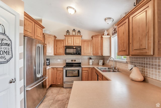 583 N 640 W, Tooele, UT 84074 - kitchen with appliances with stainless steel finishes, a sink, vaulted ceiling, decorative backsplash, and light countertops