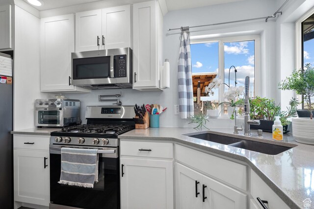 745 W Mckellar, Tooele, UT 84074 - kitchen with appliances with stainless steel finishes, a sink, white cabinets, and light stone counters