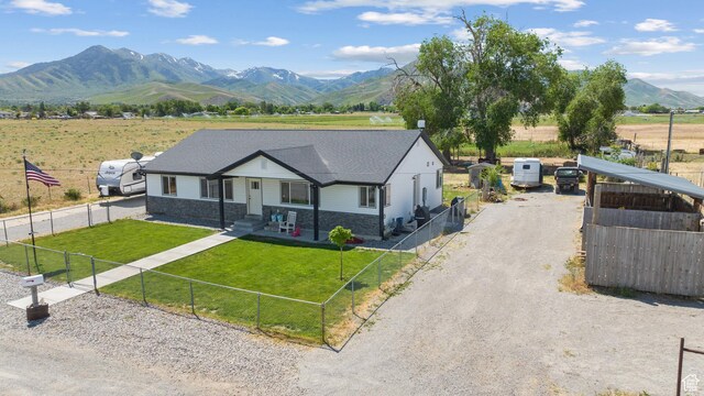 745 W Mckellar, Tooele, UT 84074 - view of front facade with a mountain view, stone siding, gravel driveway, and a rural view