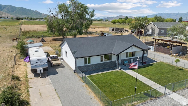 745 W Mckellar, Tooele, UT 84074 - view of front of property with a mountain view, roof with shingles, driveway, stone siding, and a view of countryside