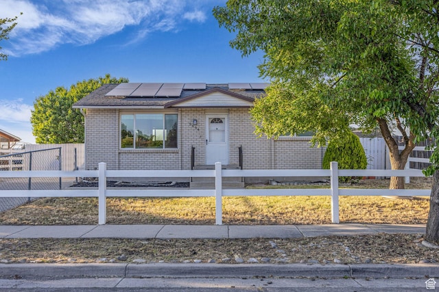 5494 W Townsend Way, West Valley City, UT 84118 - view of front of property featuring solar panels, brick siding, and a fenced front yard