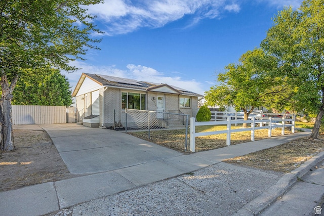 5494 W Townsend Way, West Valley City, UT 84118 - view of front of property with roof mounted solar panels, a fenced front yard, brick siding, and a gate