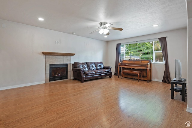 628 E Wyandotte Ave S, Sandy, UT 84070 - living room with ceiling fan, light wood-type flooring, baseboards, recessed lighting, and a tiled fireplace