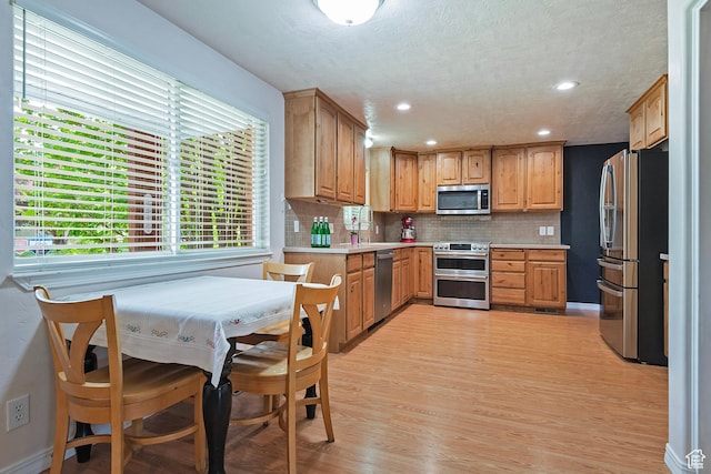 628 E Wyandotte Ave S, Sandy, UT 84070 - kitchen featuring stainless steel appliances, light countertops, tasteful backsplash, light wood finished floors, and recessed lighting