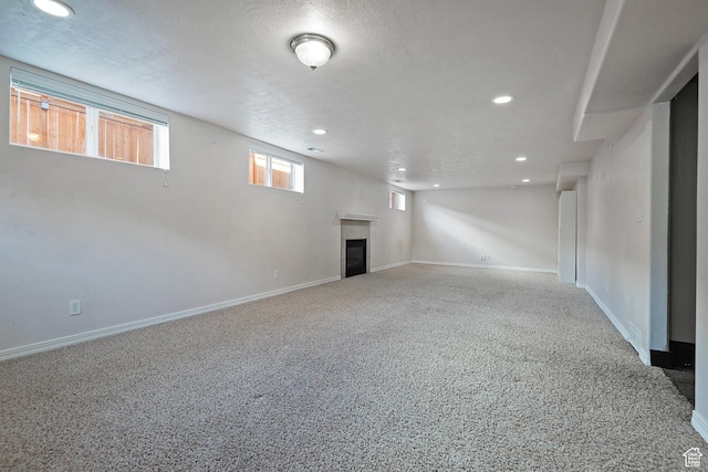628 E Wyandotte Ave S, Sandy, UT 84070 - basement with recessed lighting, carpet flooring, a tiled fireplace, baseboards, and a textured ceiling