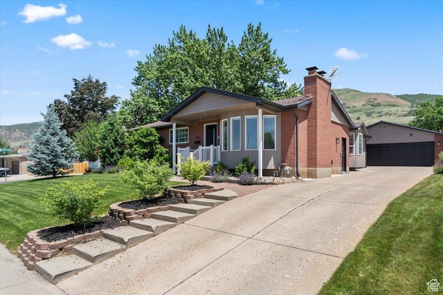 1392 N 450 E, Bountiful, UT 84010 - view of front of home with a chimney, brick siding, a front yard, a porch, and a mountain view