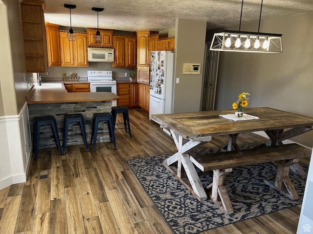 9029 N Treasureton Rd, Preston, ID 83263 - kitchen featuring white appliances, open shelves, brown cabinetry, dark wood-style floors, and a textured ceiling