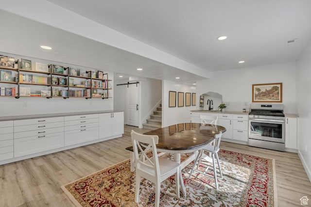 1053 E Preston Ave, Layton, UT 84040 - dining space featuring a barn door, light wood-style floors, stairway, arched walkways, and recessed lighting
